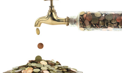 Money coins fall out of the golden tap